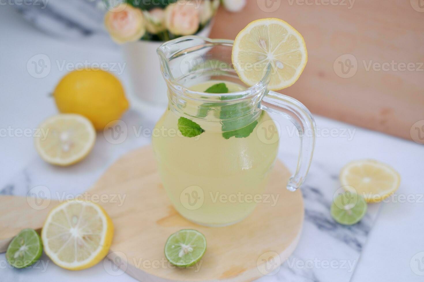 Lemonade with fresh lemon and mint leaves on a white background photo