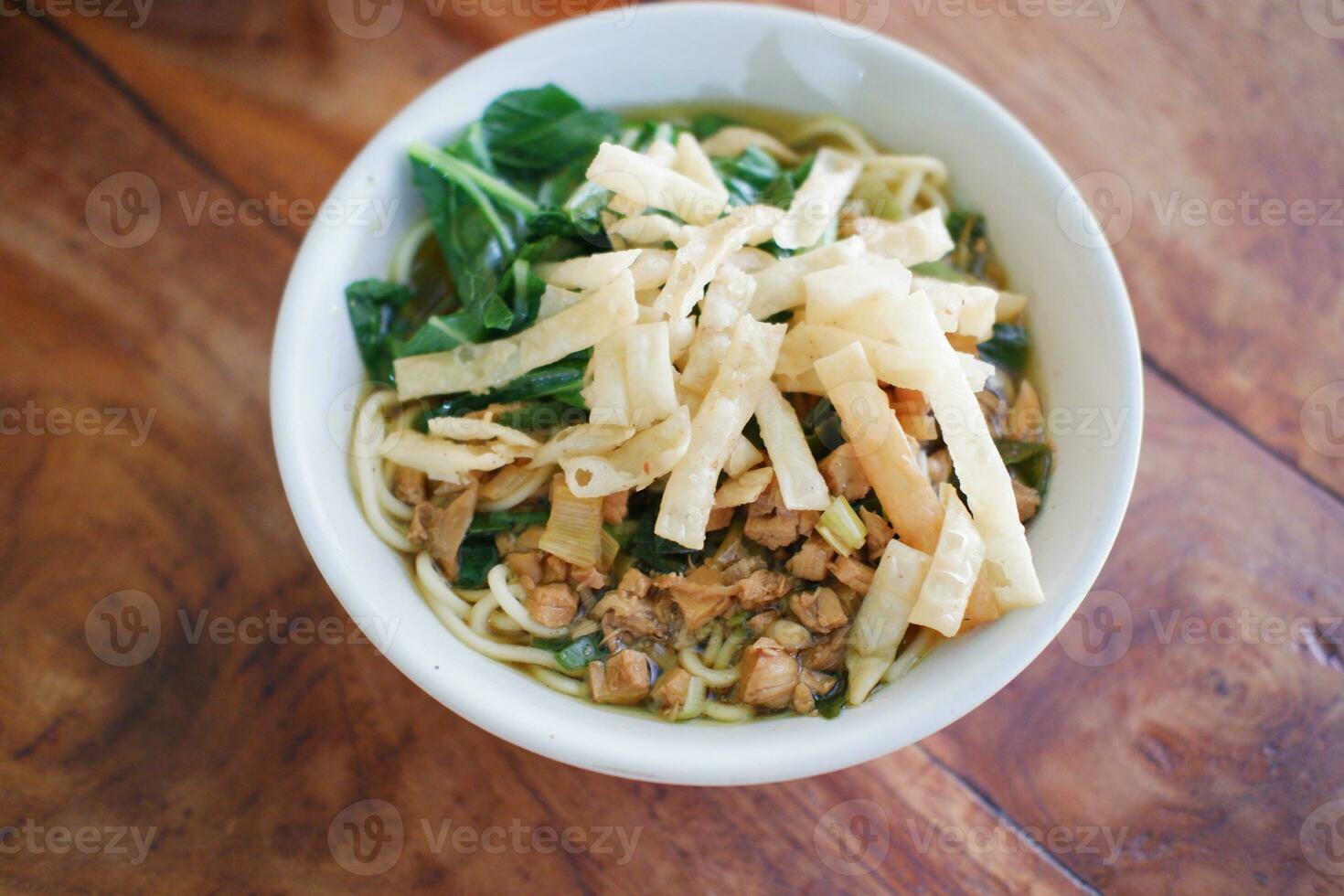 Fried noodle in white bowl on wooden table photo