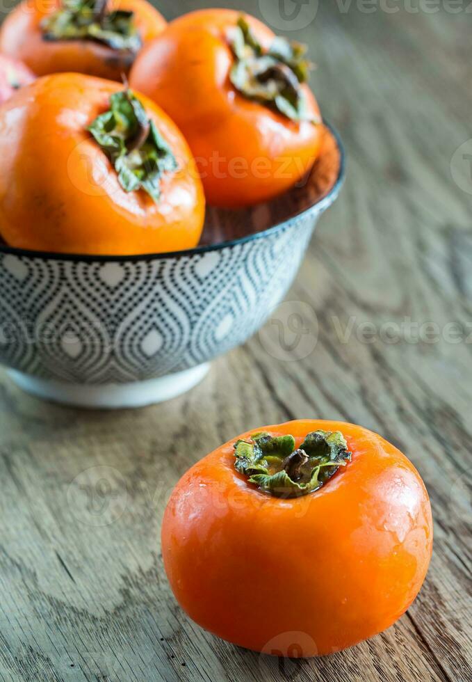 Bowl of fresh persimmons photo