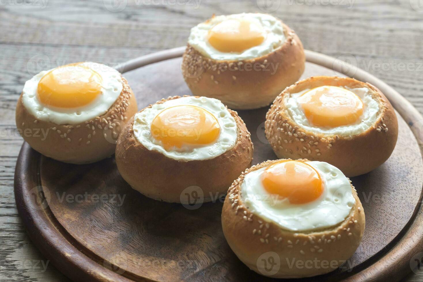 Egg-in-a-hole buns on the wooden board photo