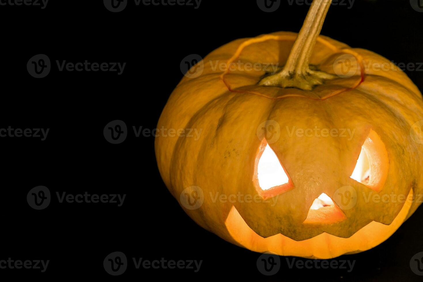 Glowing halloween pumpkin in candlelight photo