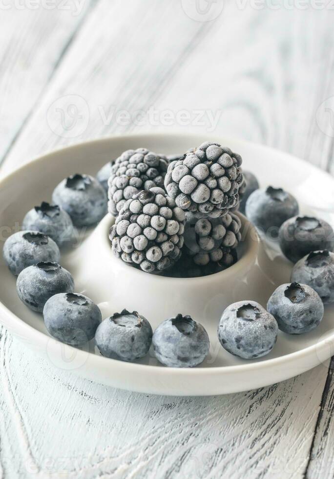Frozen blueberries and blackberries on the plate photo