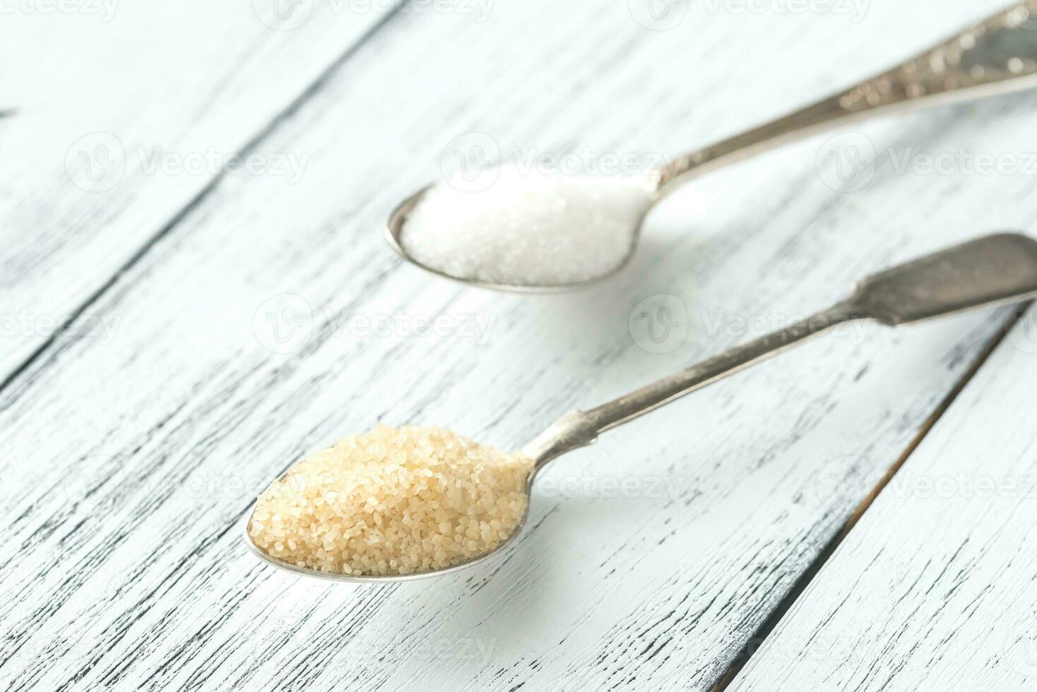 Spoons of white and brown sugar photo