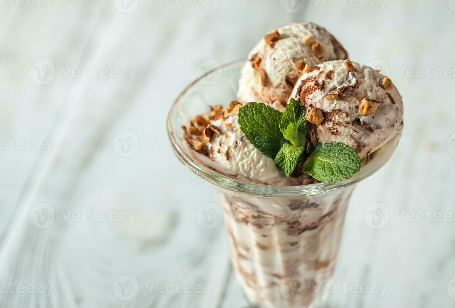 vainilla-chocolate hielo crema en un helado con frutas y nueces vaso foto
