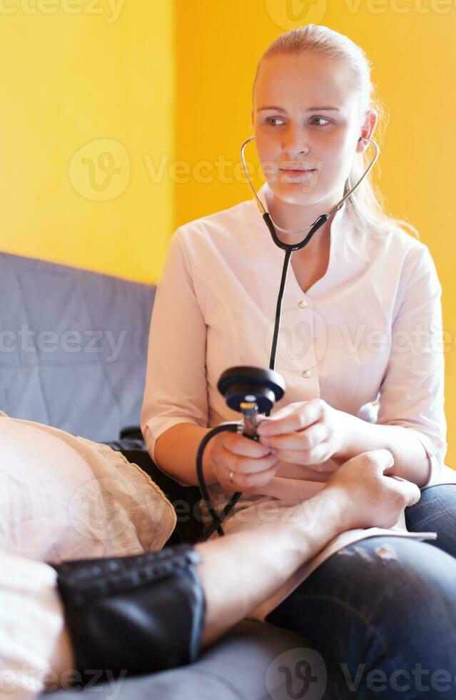 Nurse measures the patient blood pressure photo