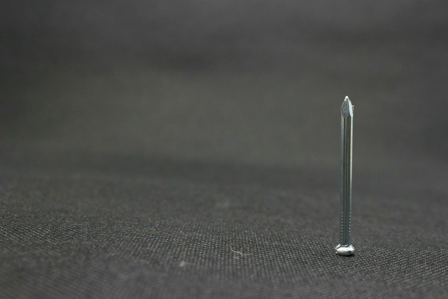 Concrete nail on a black background photo