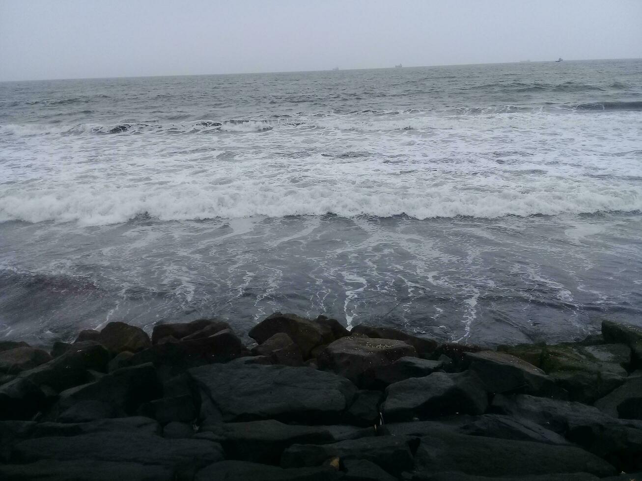 ver de el olas y rocas en el playa foto