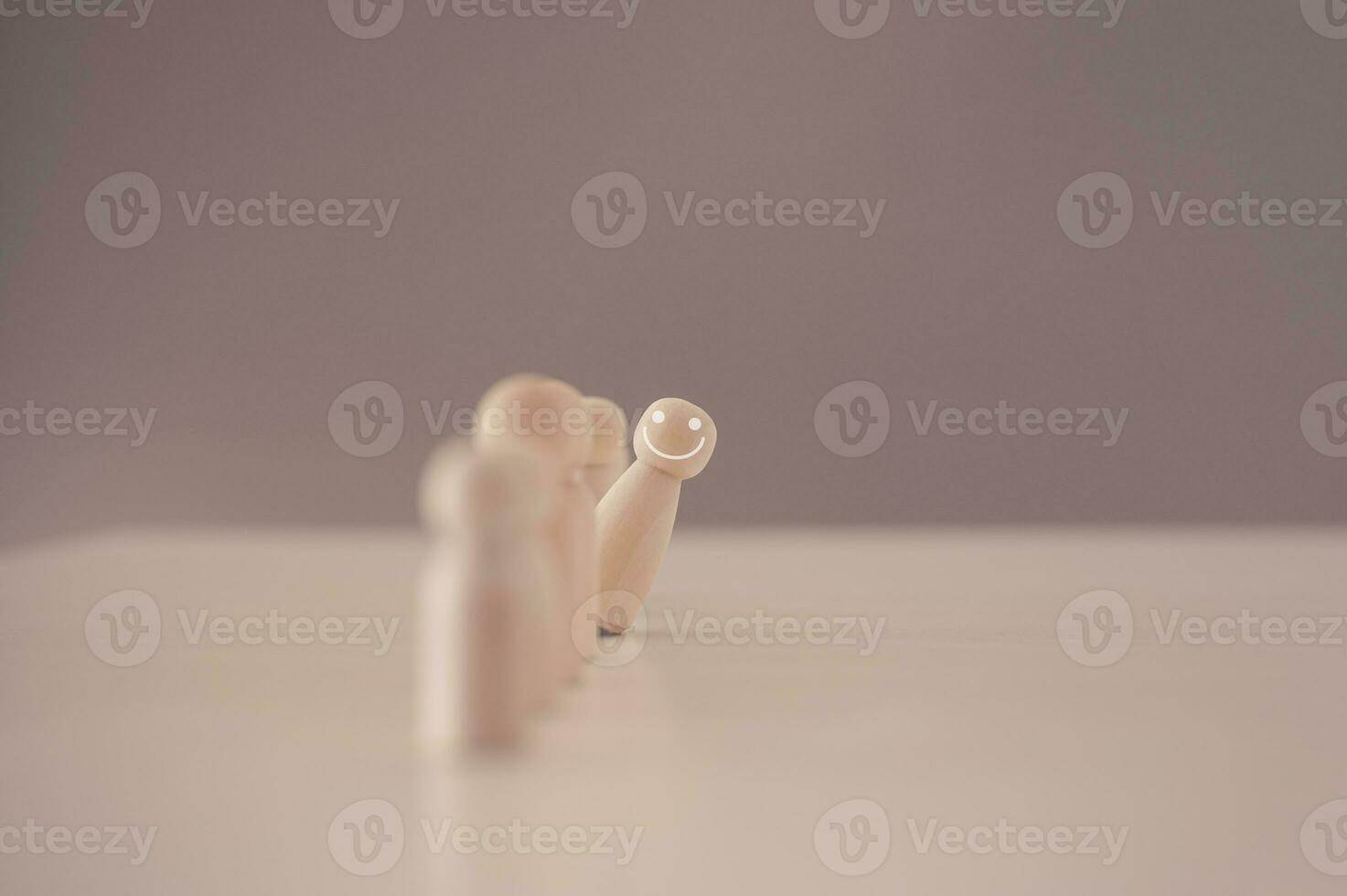 Volunteer leader outstanding talent stand out from the crowd and different concept. smile wooden figure from group of crowd. business management and human development concept, brave team leader photo