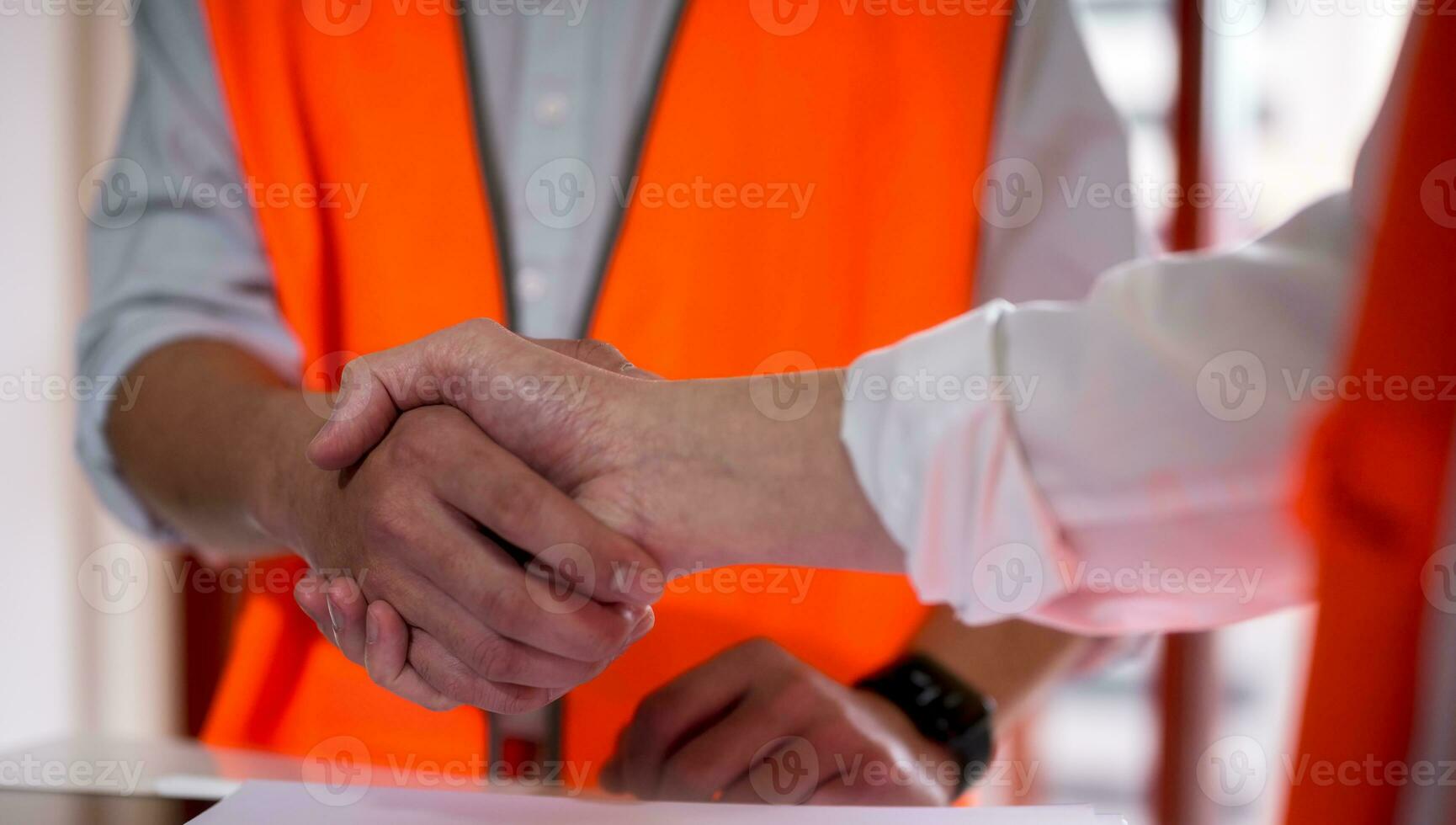 Engineers or foreman shaking hands at construction site, Construction worker in protective uniform shaking hands at construction site photo