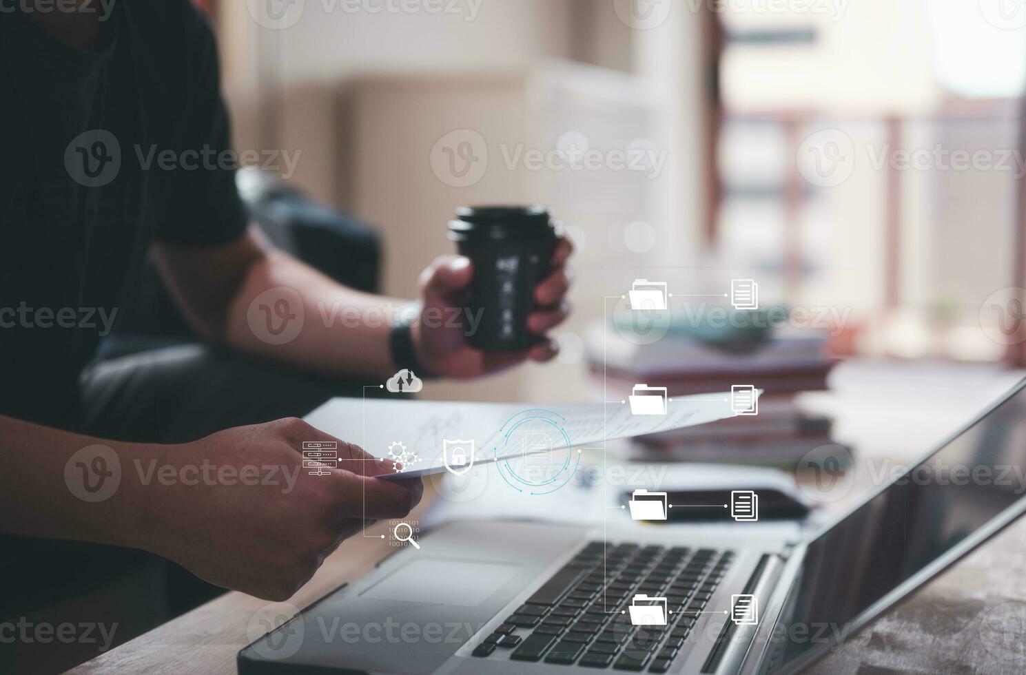 Man holding paper work  report in concept of data analysis and document management system, sitting and working on computer with document in blurred office background photo