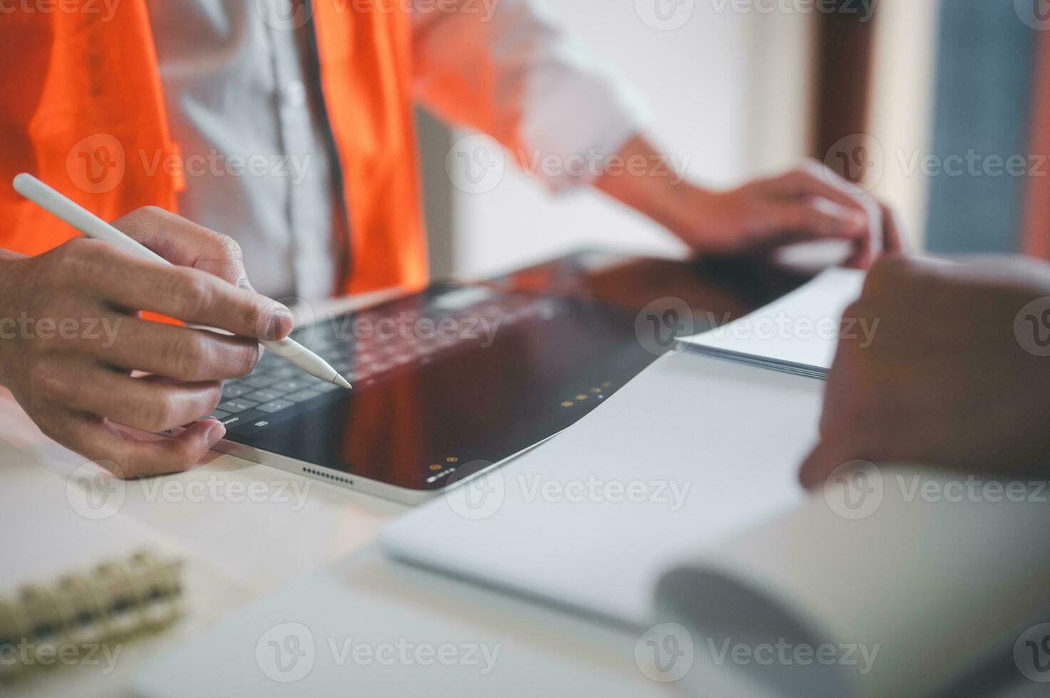 engineer or foreman using tablet and pen presenting or discussing project plan with co worker photo