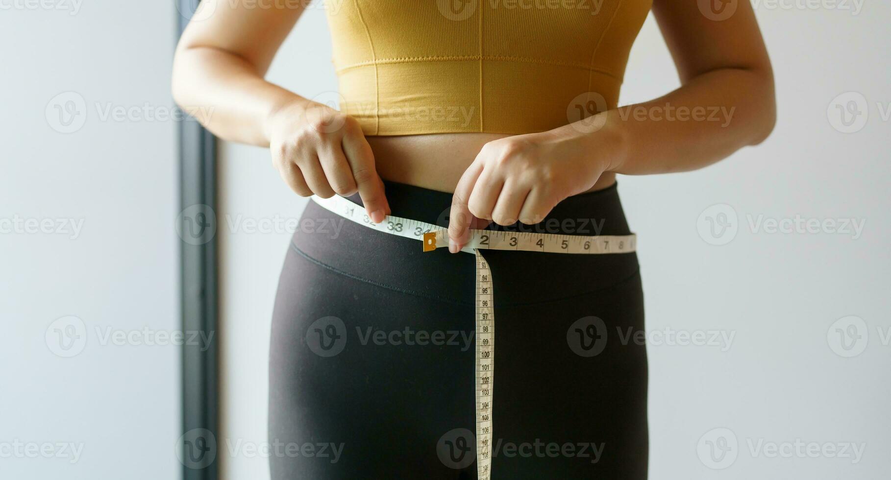 woman want to lose weight with a centimeter Shape up healthy stomach muscle and diet measuring waist with measure tape after diet weight control photo