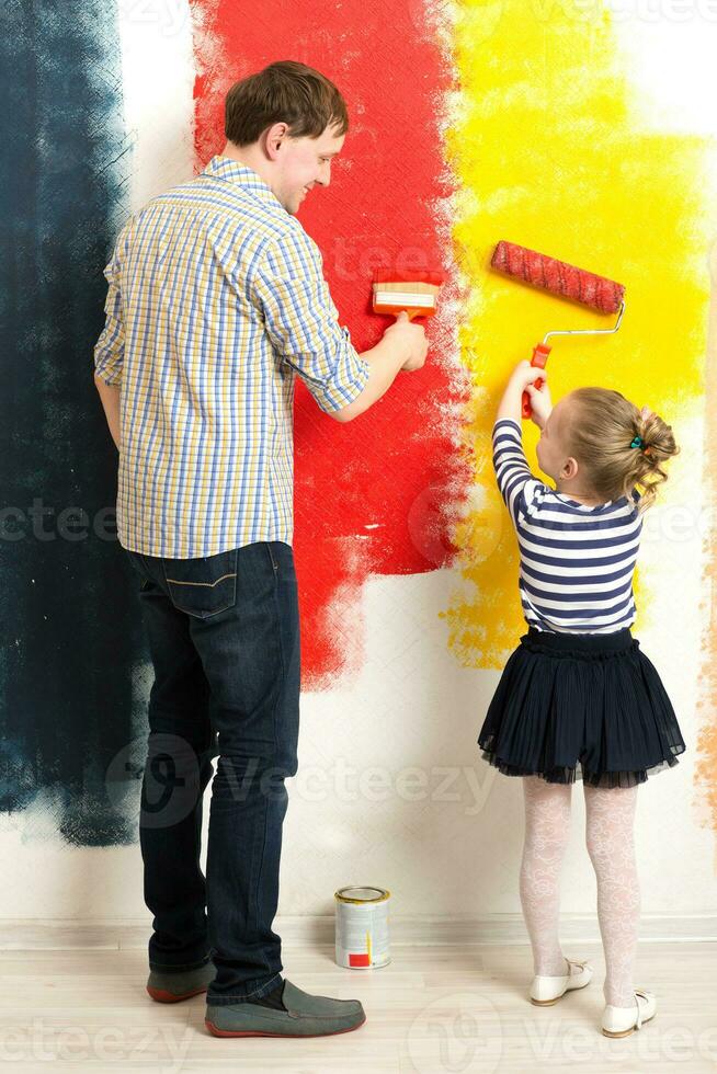 Father and daughter painting wall photo