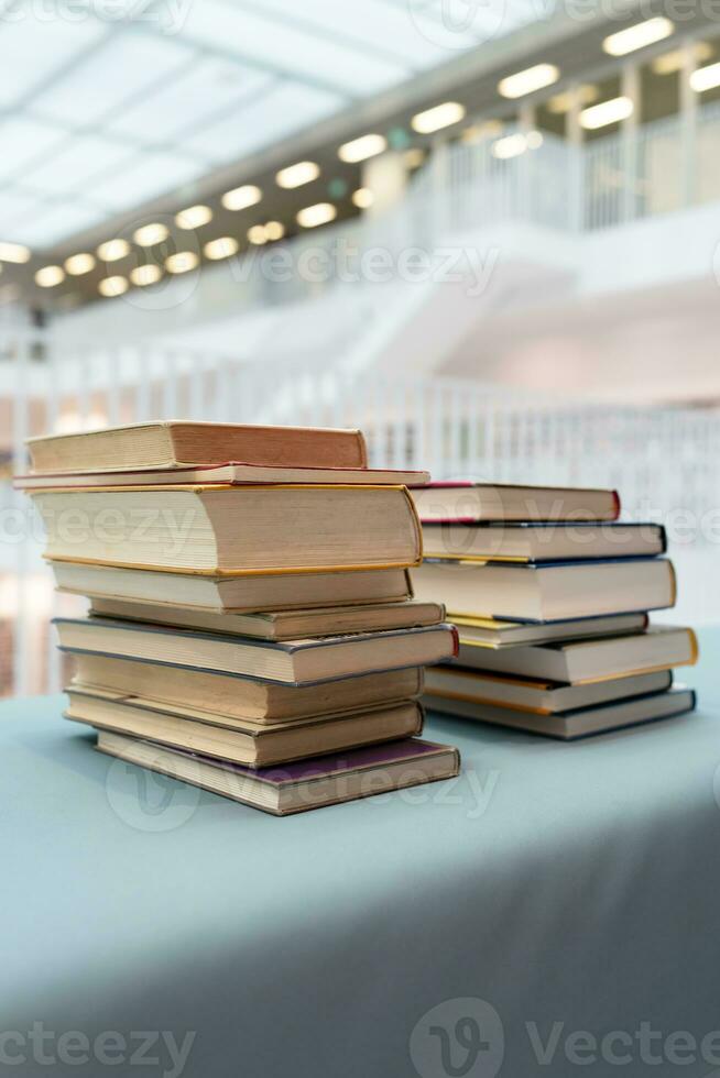 un apilar de libros acostado en el mesa. un lote de libros son en el mesa. un grande apilar de libros son recogido en uno lugar. foto