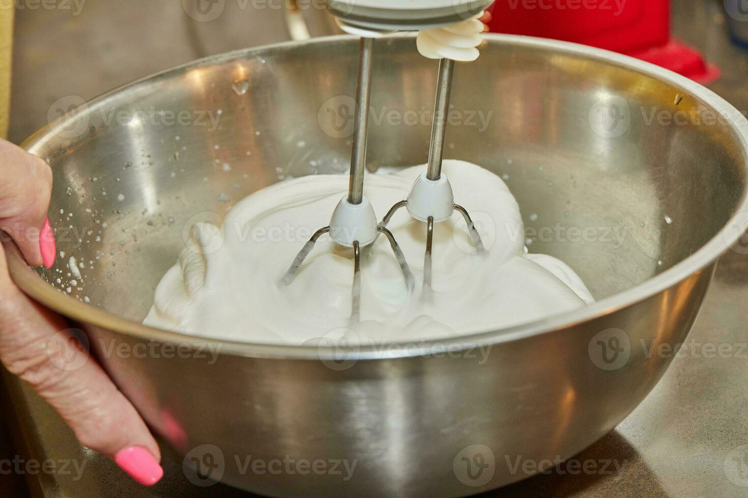 cocinero látigos el huevo ropa blanca con mezclador en cuenco foto