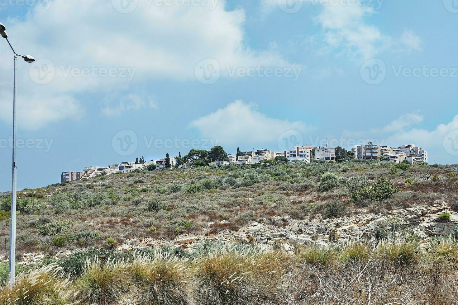View of Haifa region on mountain slope against sky with clouds photo