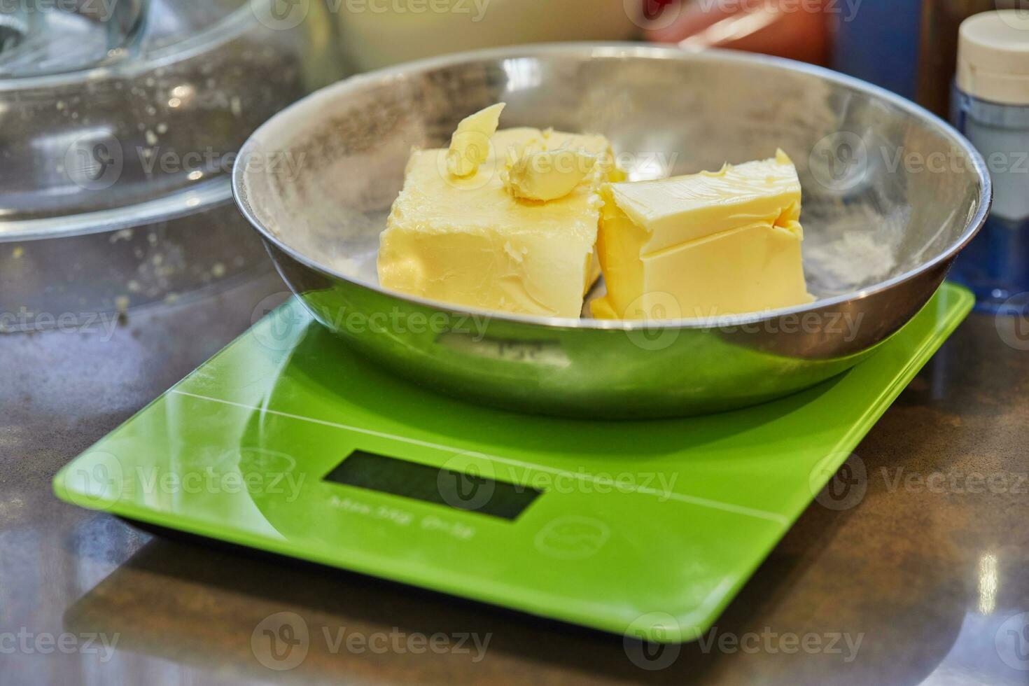 Butter in metal plate on digital scale in home kitchen photo