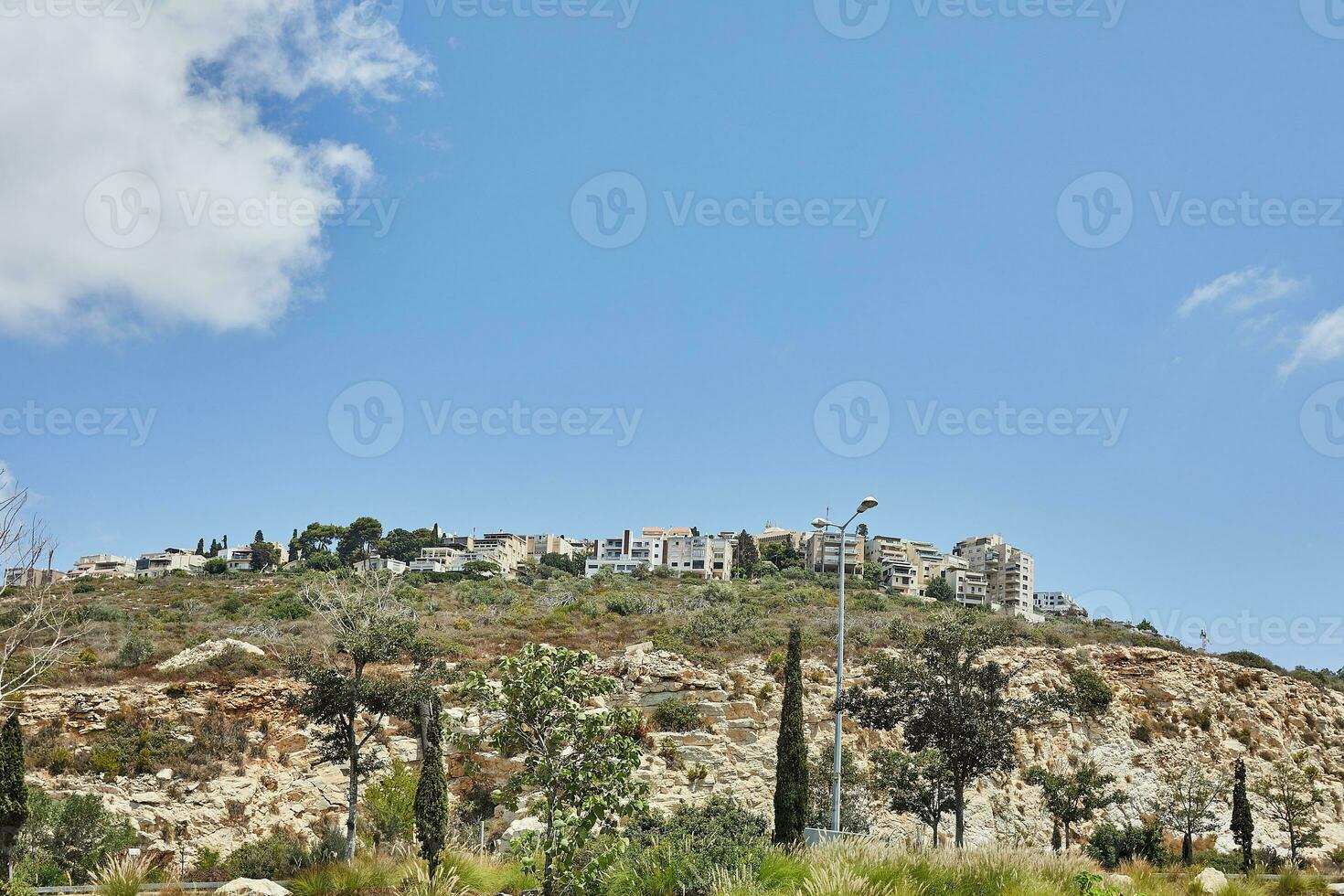 View of Haifa region on mountain slope against sky with clouds photo