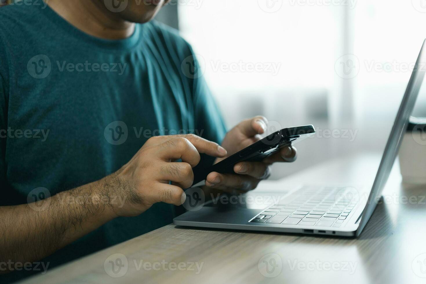 Man using smartphone after working with laptop on table, businessman using mobile phone to search or social media or shopping online. Business concept smart phone technology conversation conferrence. photo