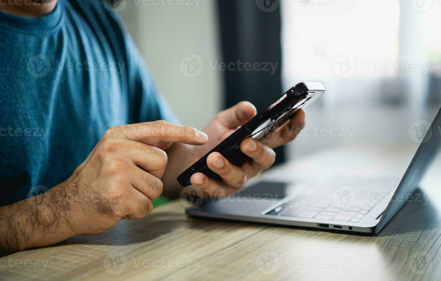 Man using smartphone after working with laptop on table, businessman using mobile phone to search or social media or shopping online. Business concept smart phone technology conversation conferrence. photo