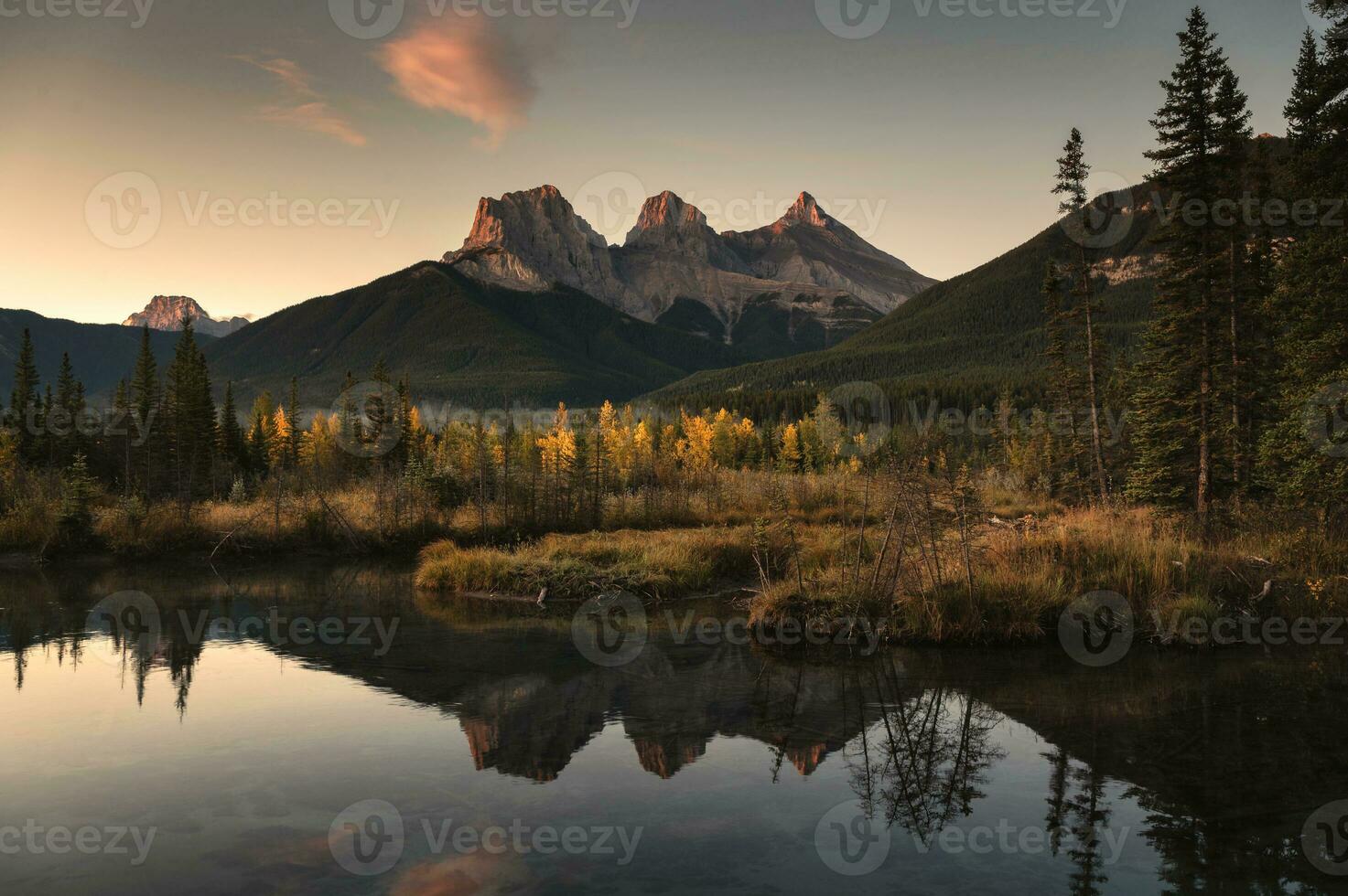 Scenery of Three Sisters Mountains reflection on autumn forest in the morning at Canmore, Banff national park photo