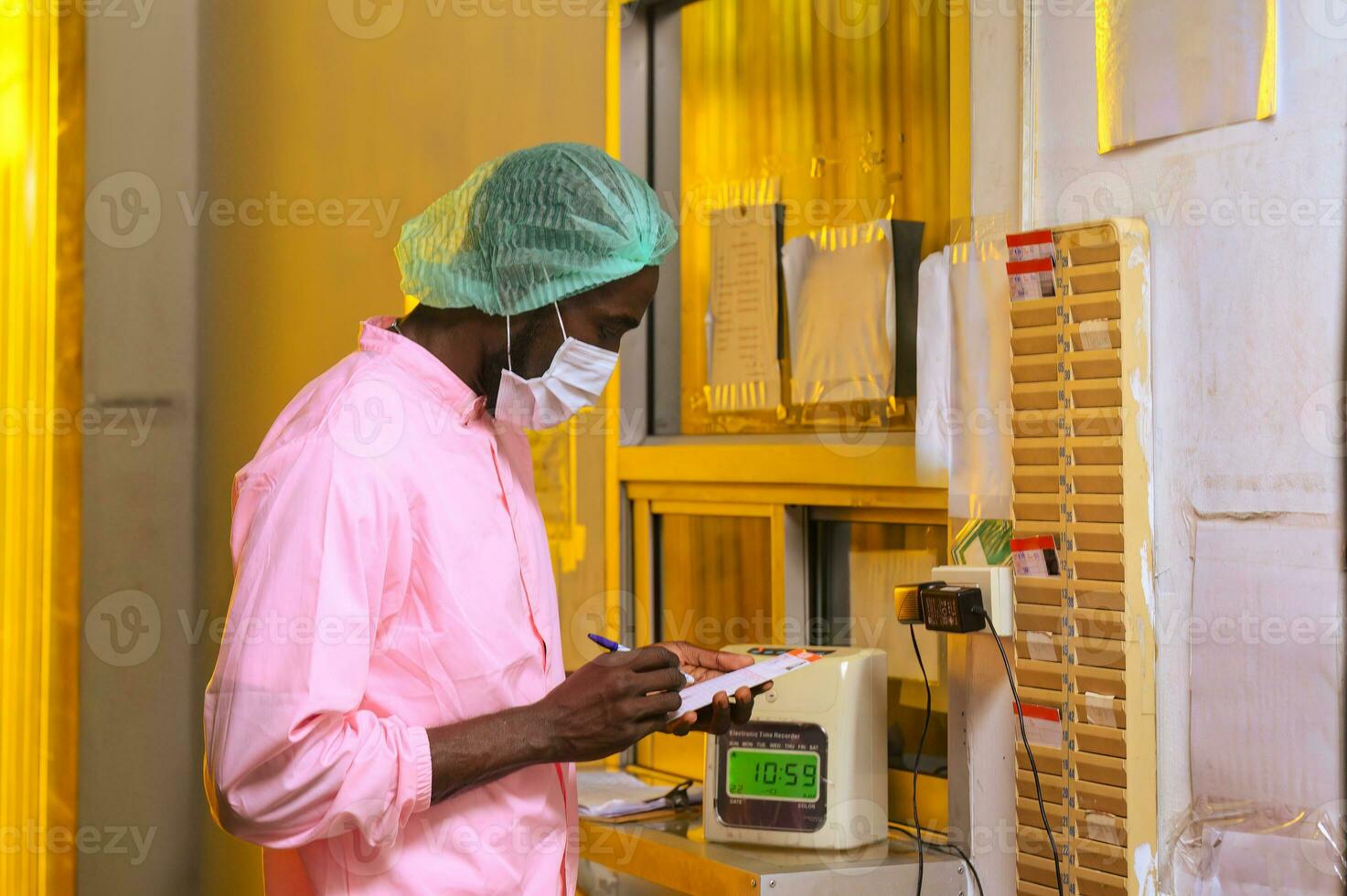 Employee male writing time card to start working at processing plant photo