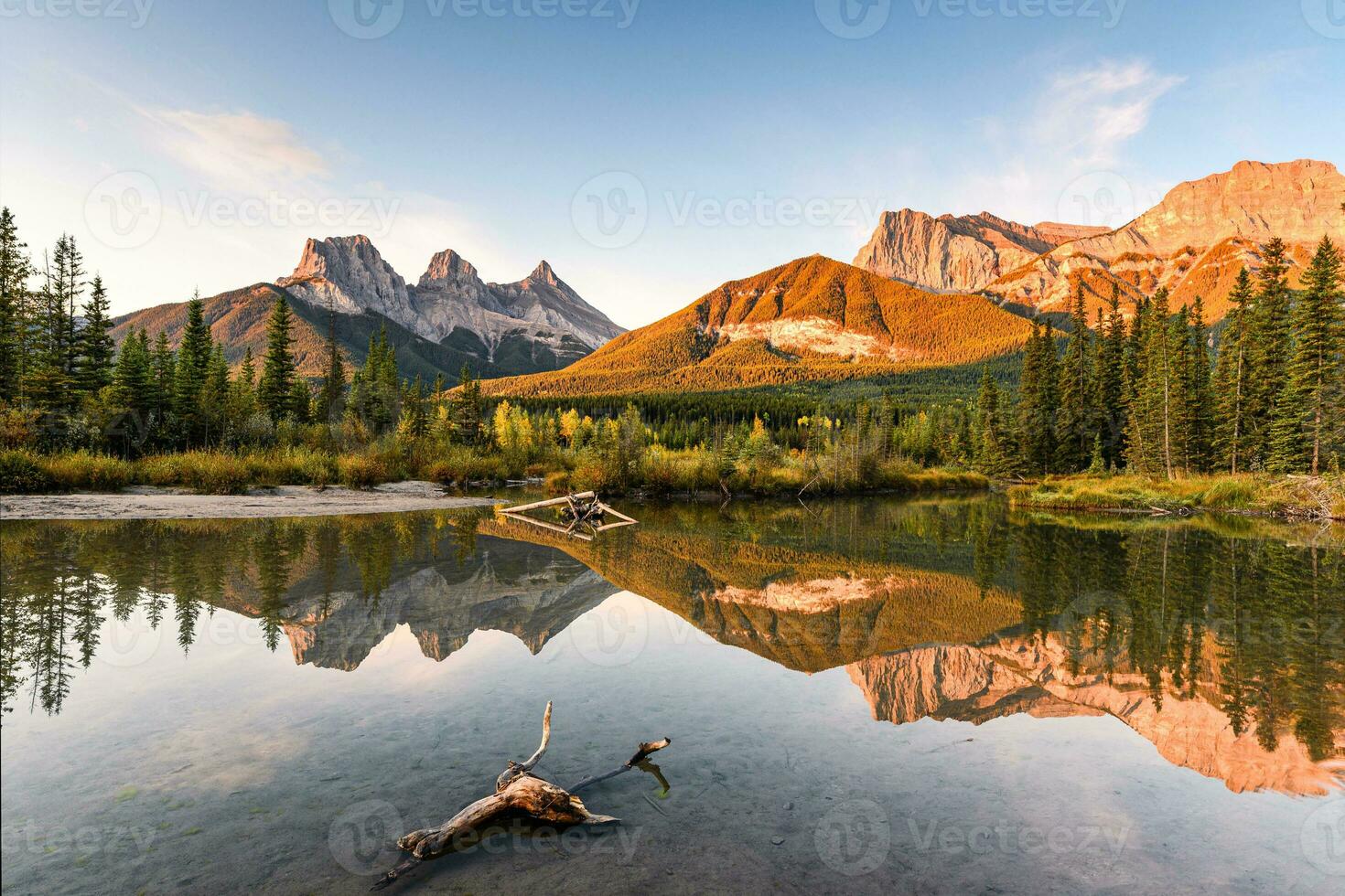 Scenery of Three sisters mountain reflection on pond at sunrise in autumn at Banff national park photo