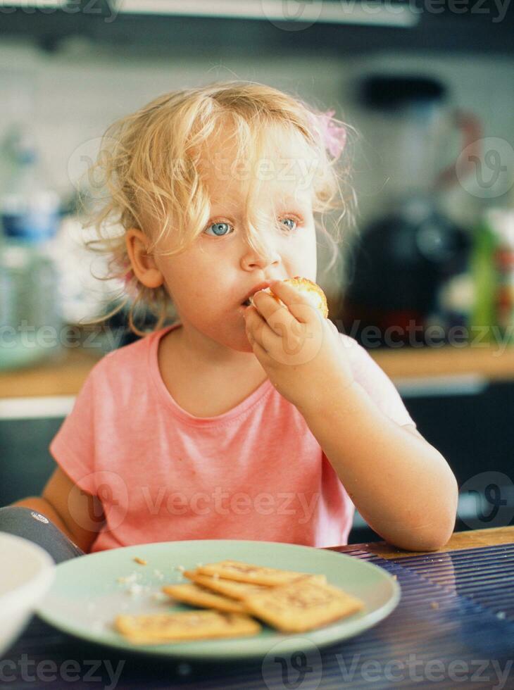 Mañana retrato de un bebé niña durante desayuno foto