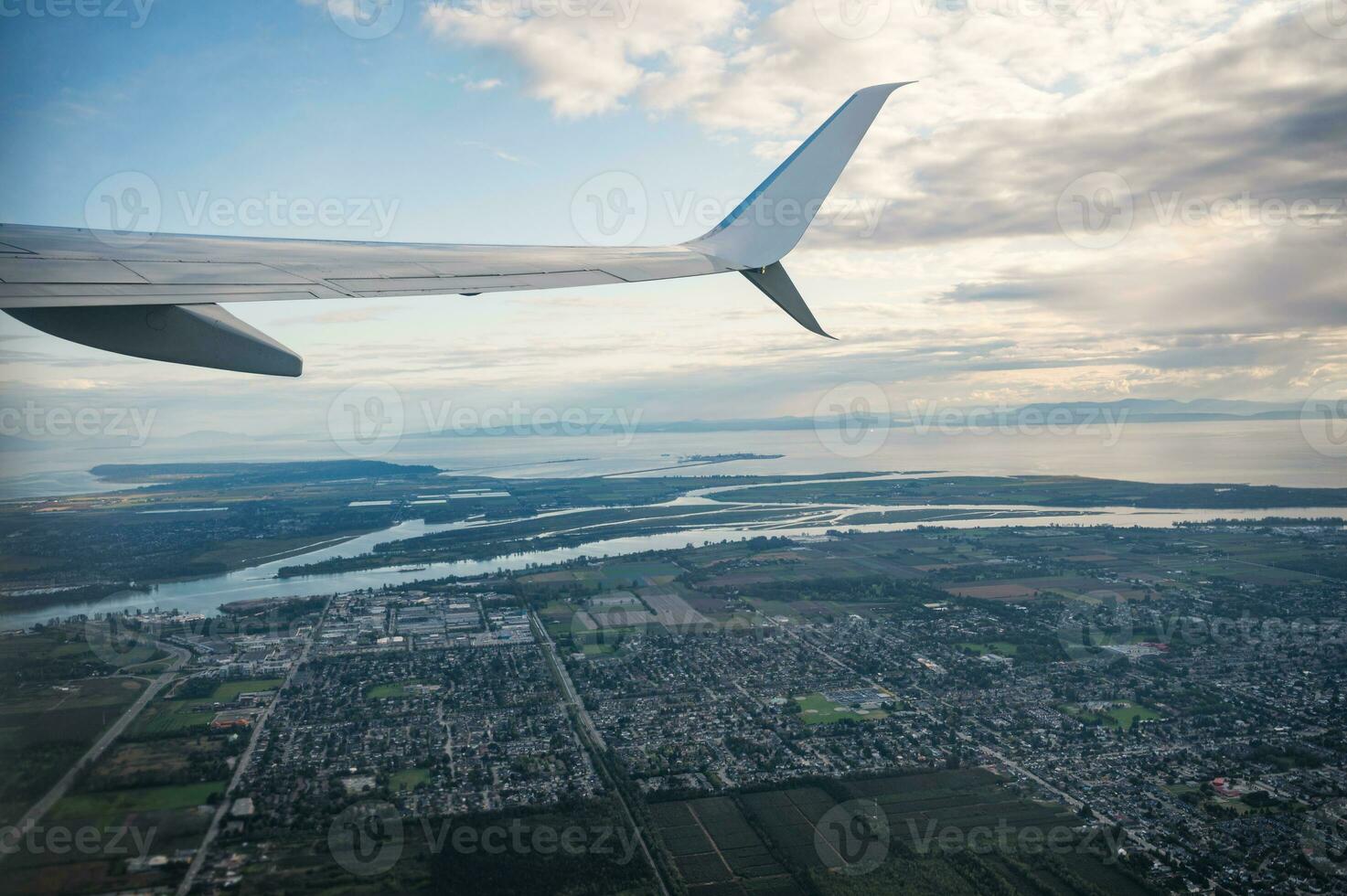 View from airplane with crowded downtown and large river connected to the sea photo