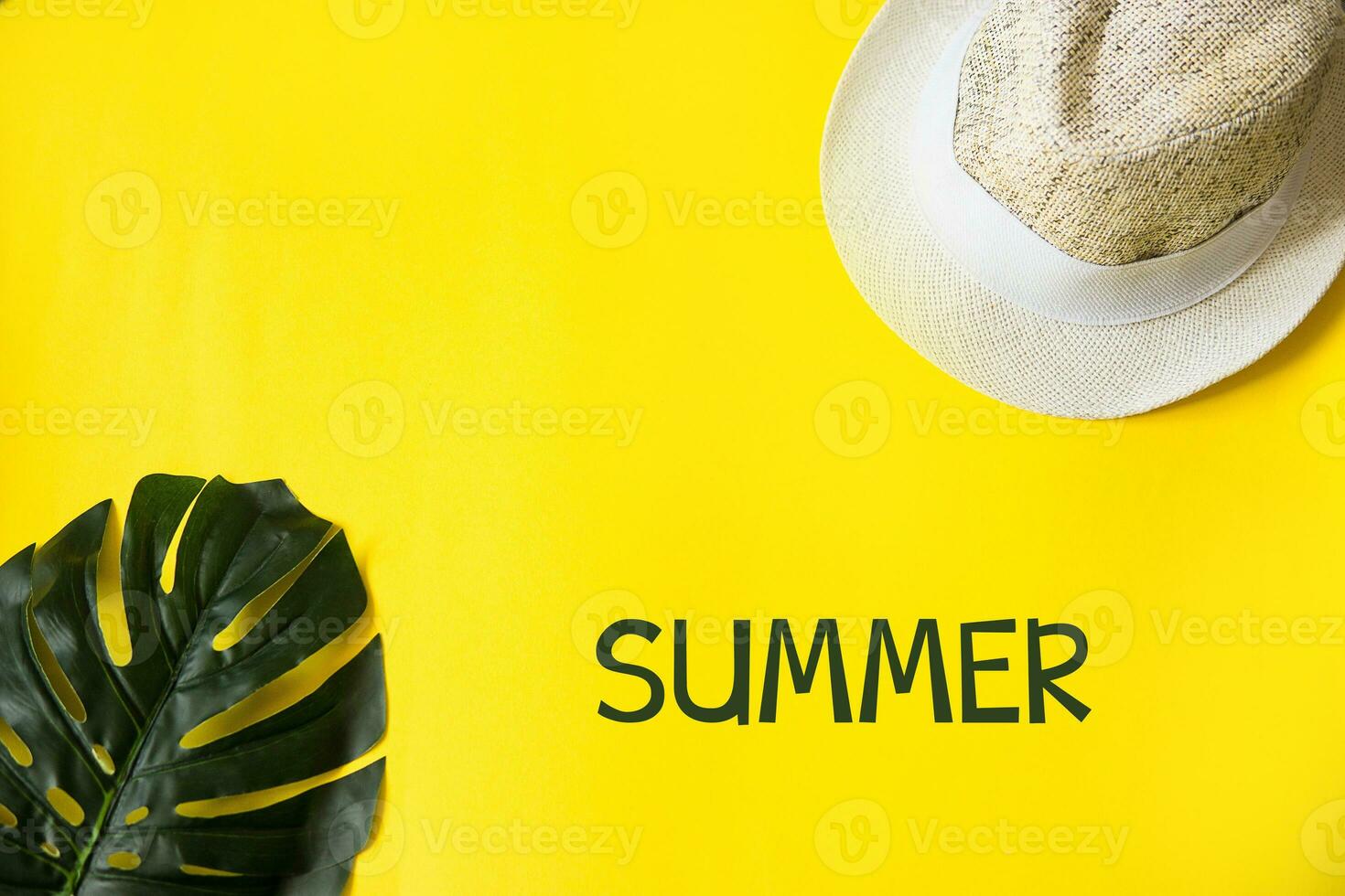 Beach accessories on the yellow background - sunglasses and striped hat. Summer is coming concept.Tropical leaves Monstera. Summer flat lay, top view. Text Summer. photo