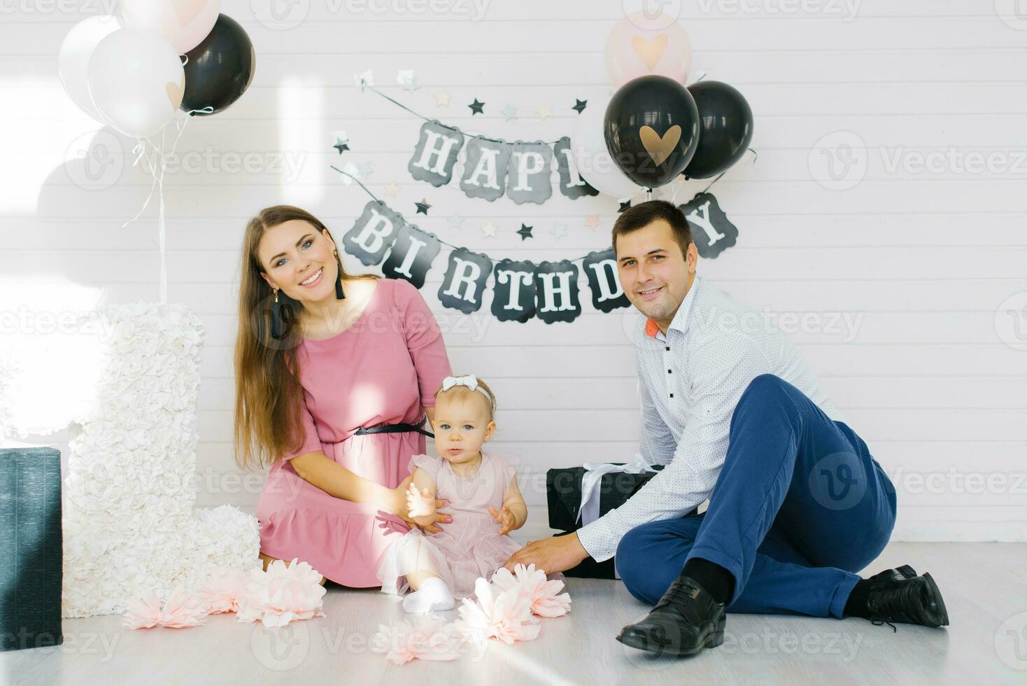 un hermosa familia es celebrando su hija primero cumpleaños. foto zona para un fiesta
