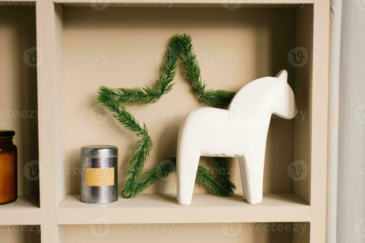 Christmas decor of a cozy Scandinavian-style house. White wooden horse, spruce star on the shelf photo