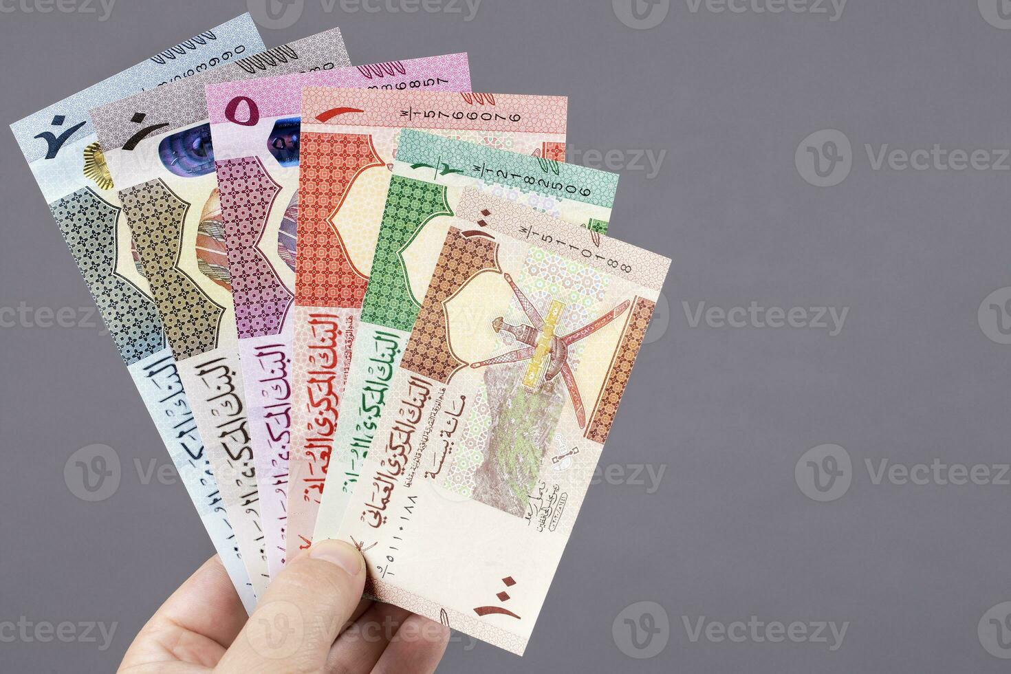 Omani money in the hand on a gray background photo