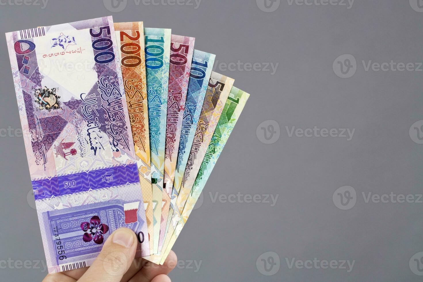 Qatari money in the hand on a gray background photo