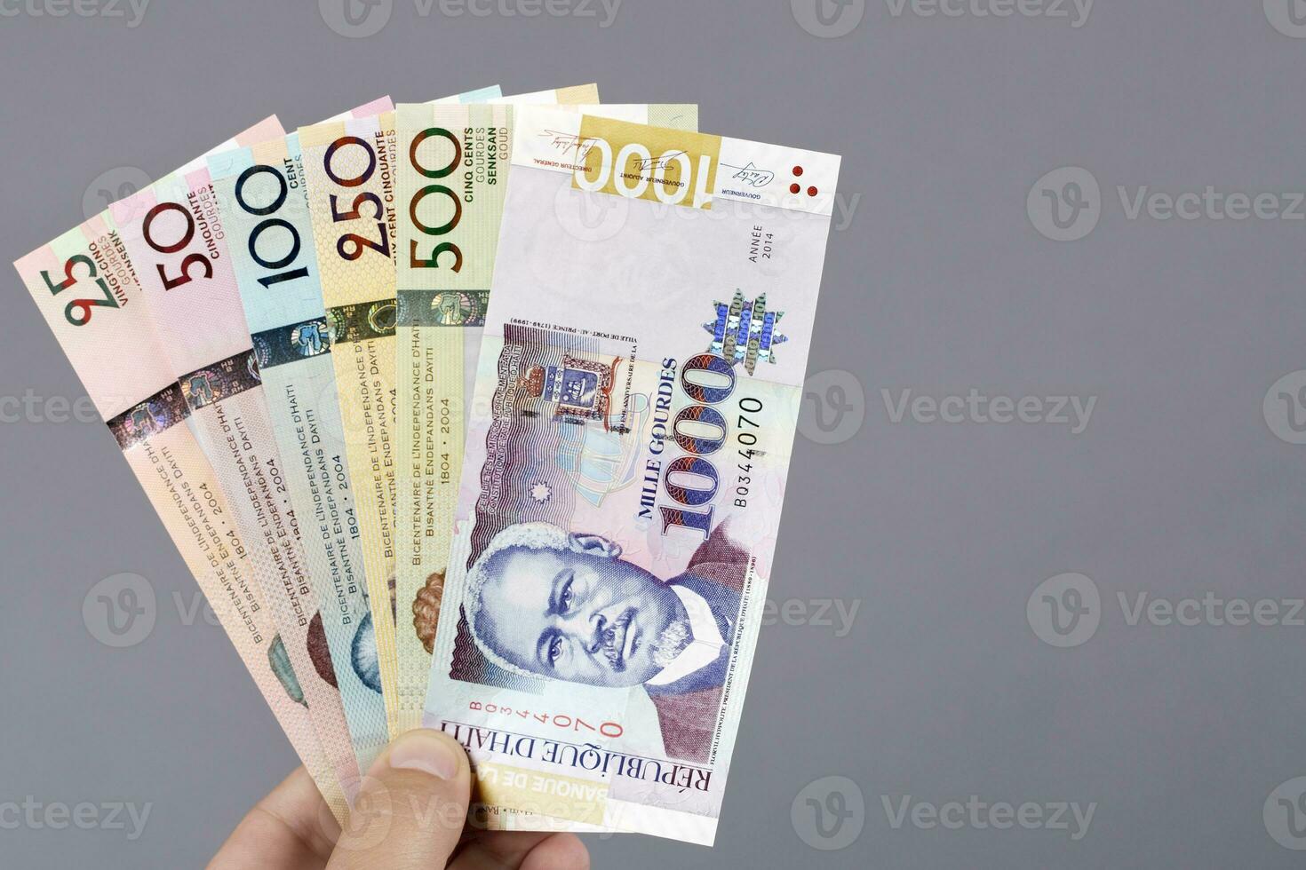 Haitian money in the hand on a gray background photo