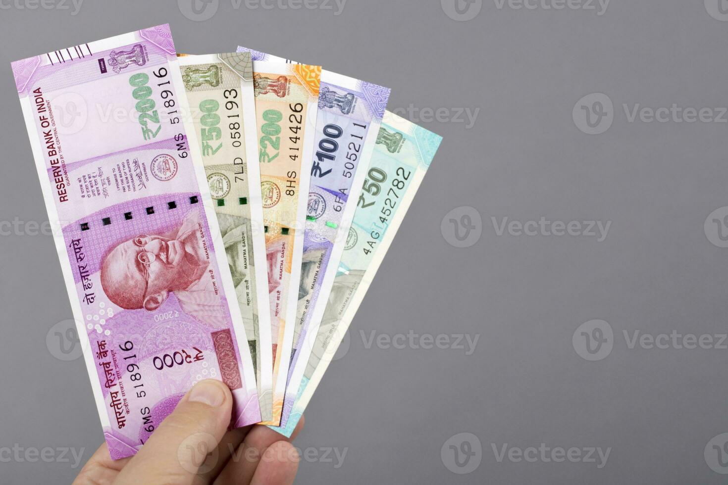 Indian money in the hand on a gray background photo