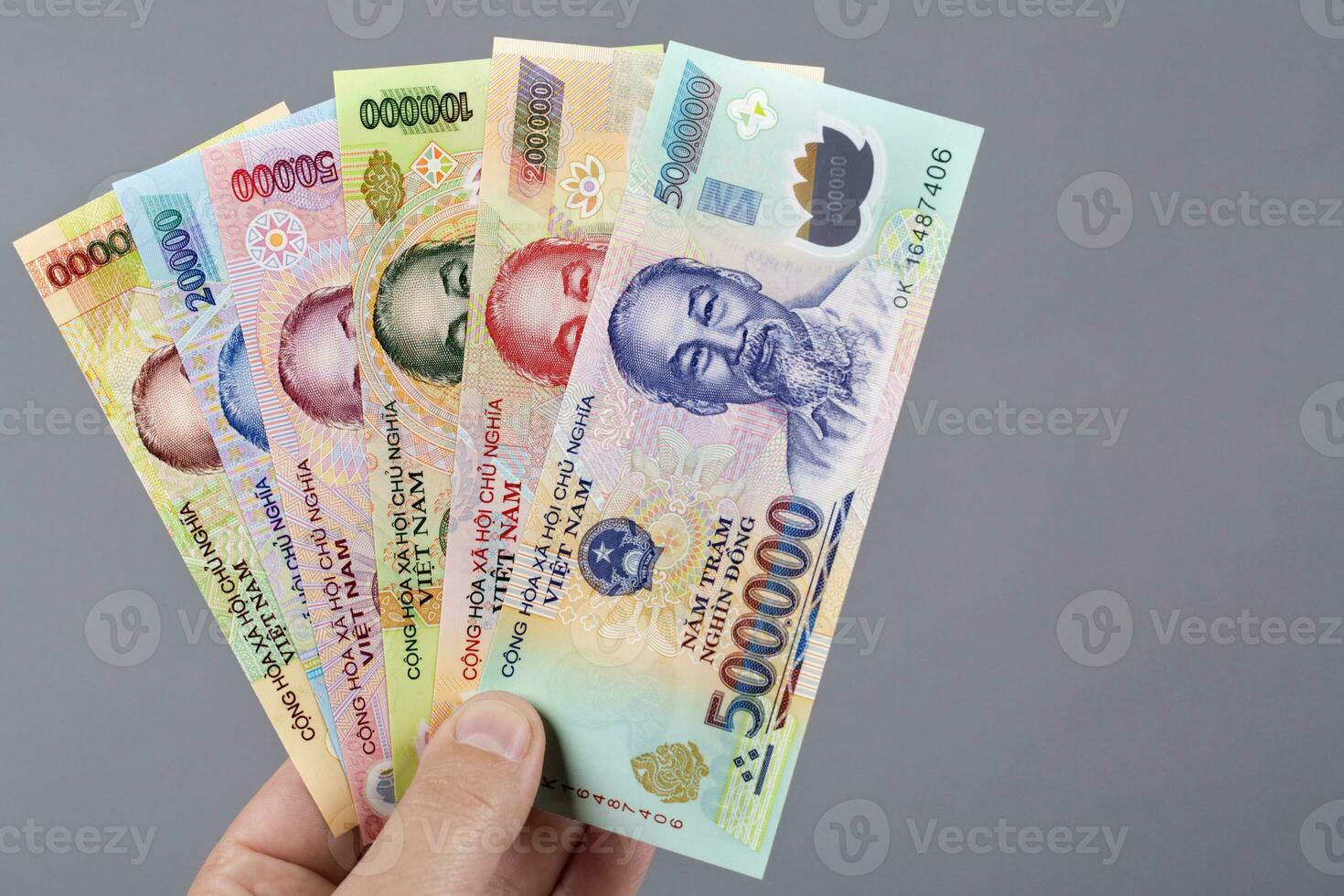 Vietnamese money in the hand on a gray background photo