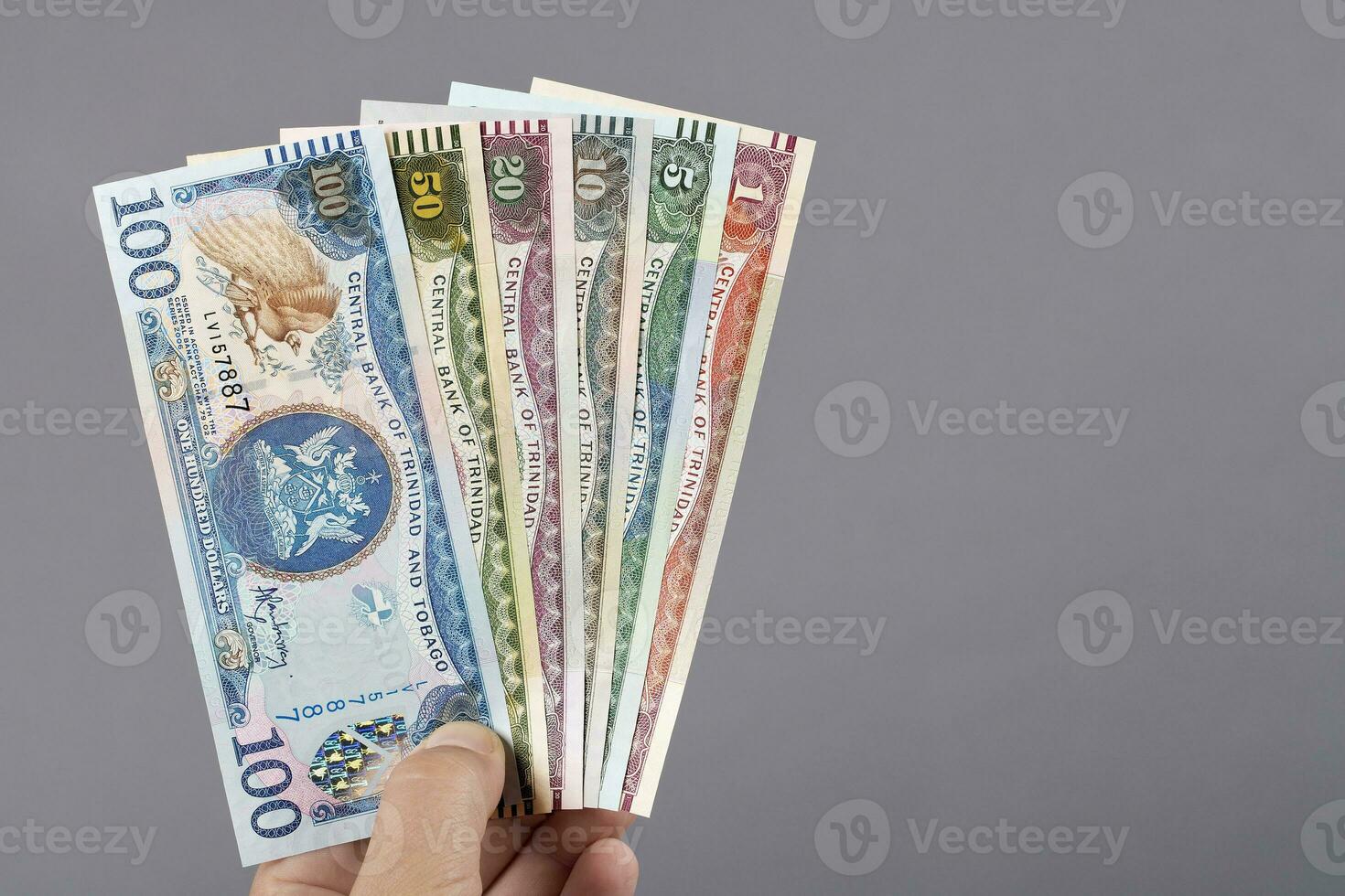 Old Trinidad and Tobago money in the hand on a gray background photo