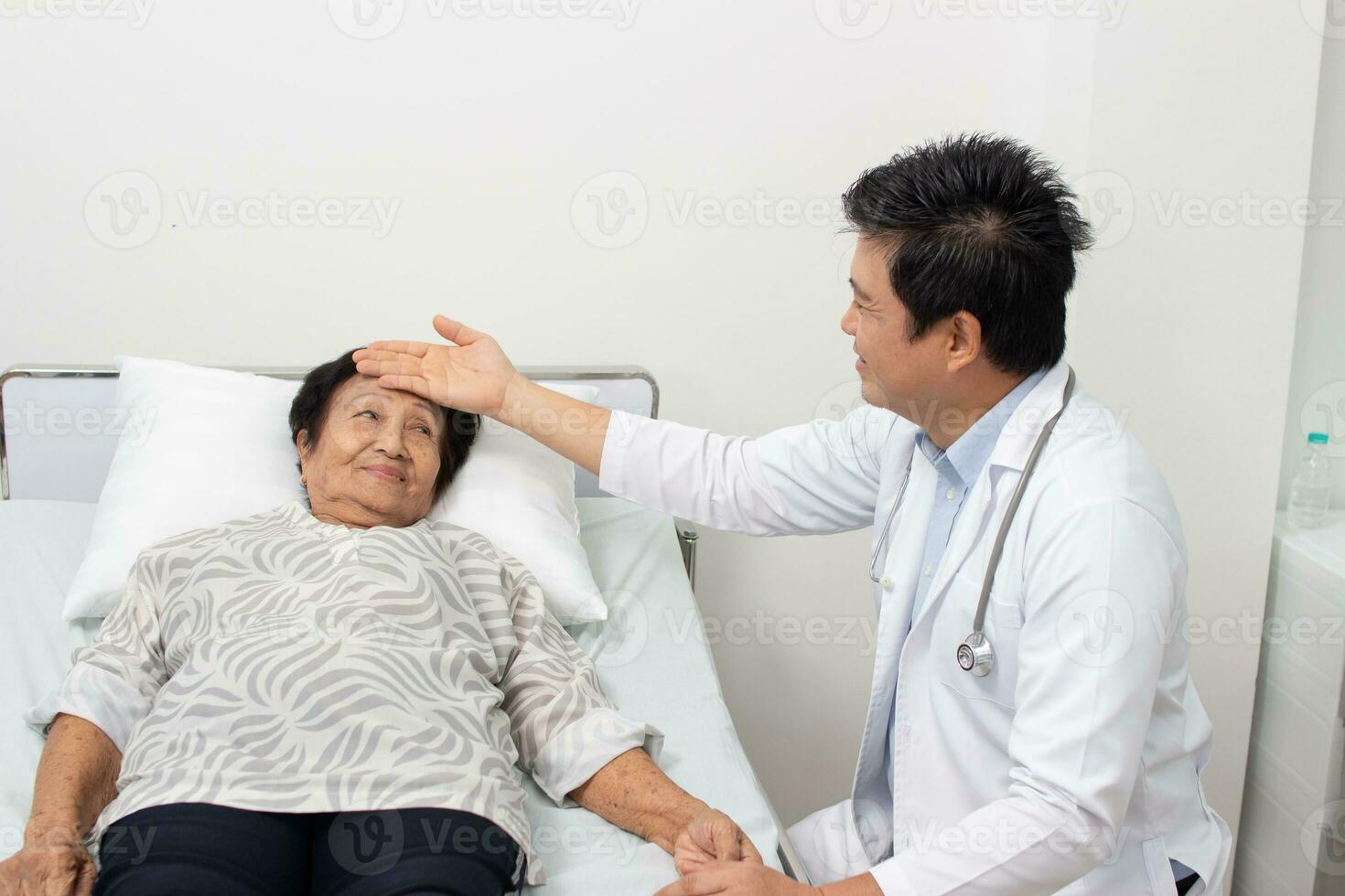 male doctor discussing over medical record with senior woman in hospital. photo