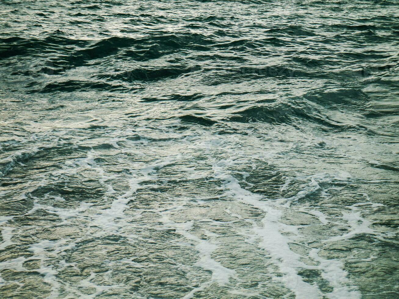 ver de pequeño olas con espuma foto