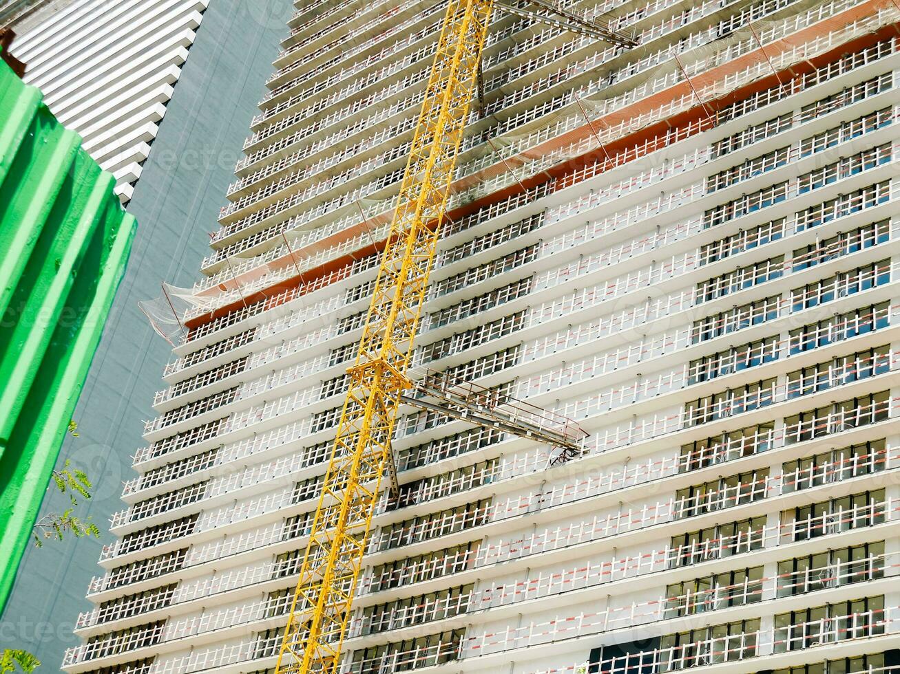 Modern unfinished skyscraper with a lifting crane. photo