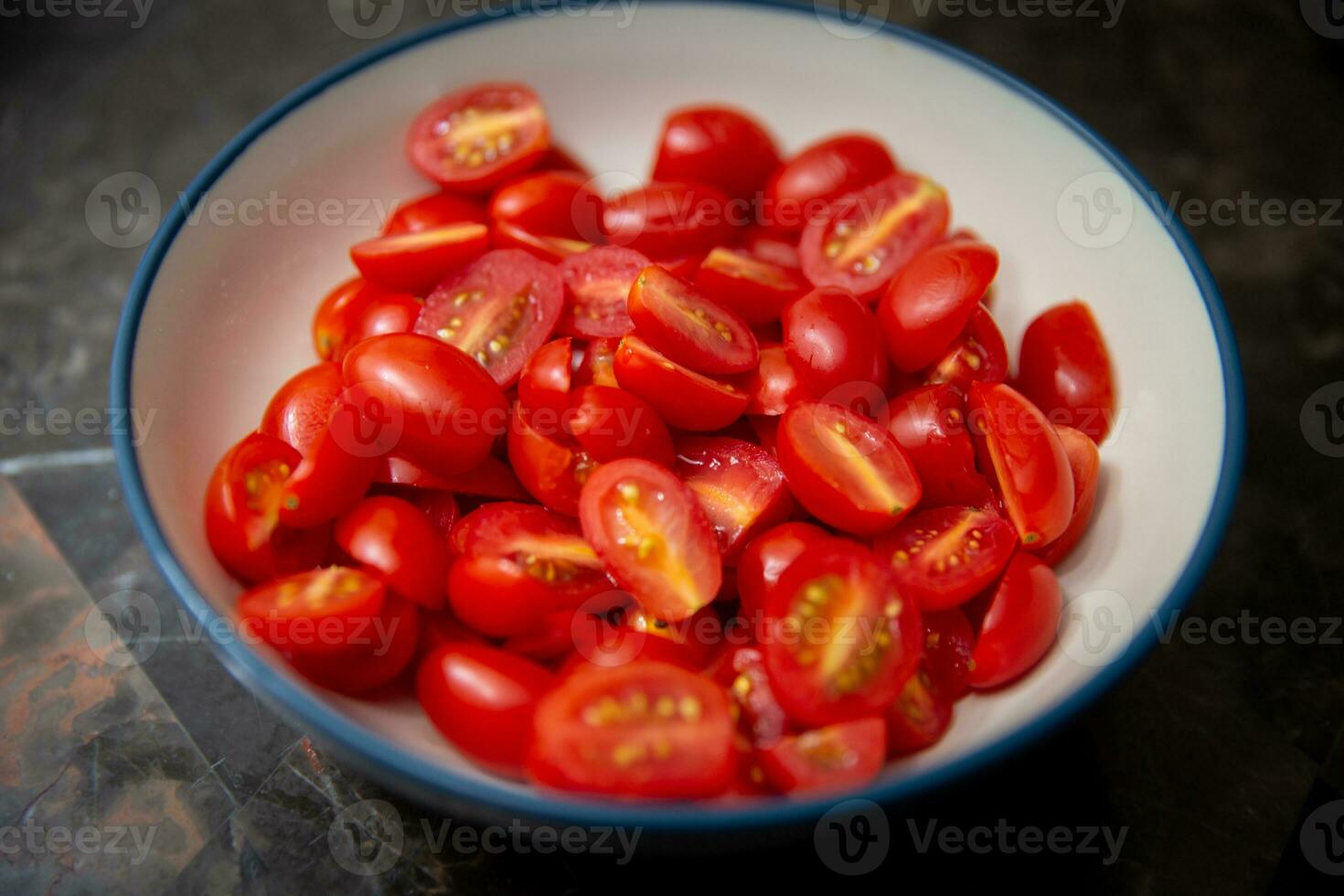 Bowl of small sliced tomatoes photo
