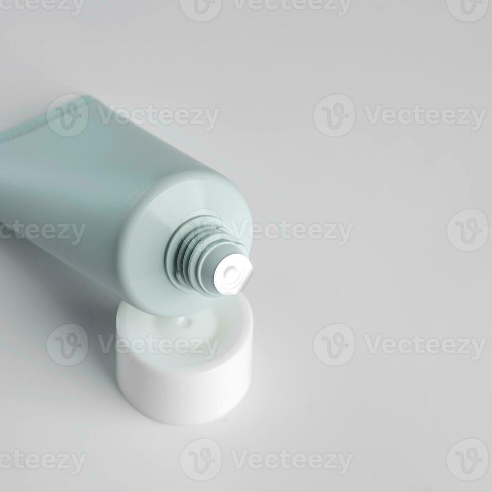 close up of open plastic aqueeze tube with cream, toothpaste, lotion or medicine on white background. New package before use. Cosmetics mockup photo