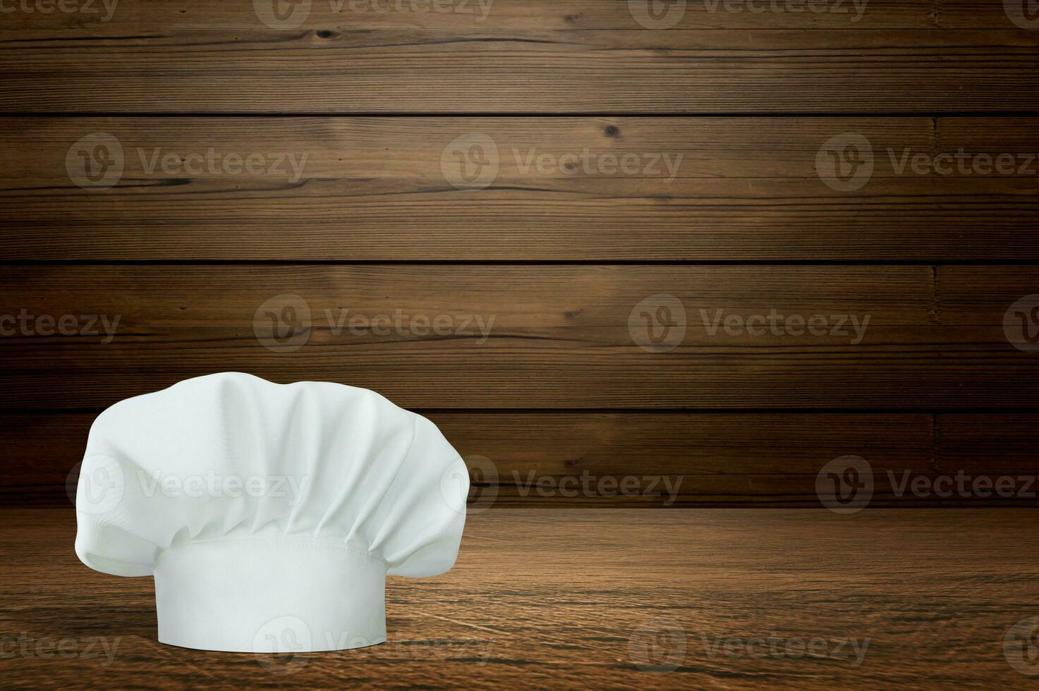 Wooden table with empty space and chef's hat photo