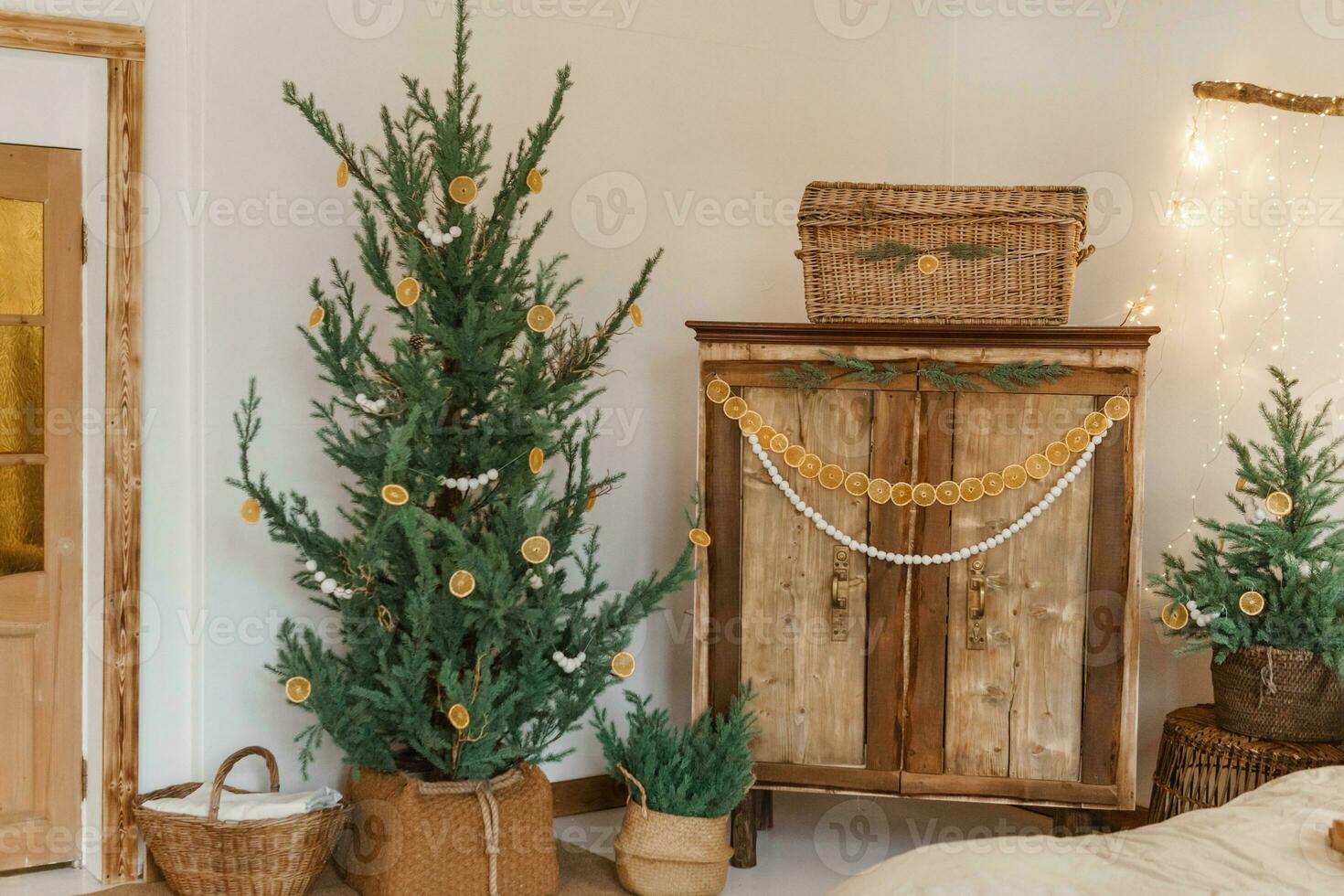 Cozy interior decorated for Christmas in Scandinavian style. Live fir trees decorated with natural ornaments made of dried oranges photo