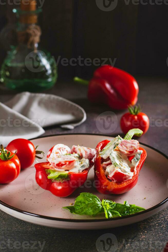 Fresh bell pepper stuffed with cucumber, tomato and greek yogurt on a plate vertical view photo