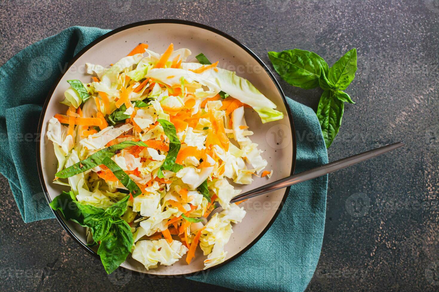 Close up of traditional cole slaw salad of cabbage, carrots and greens on a plate top view photo