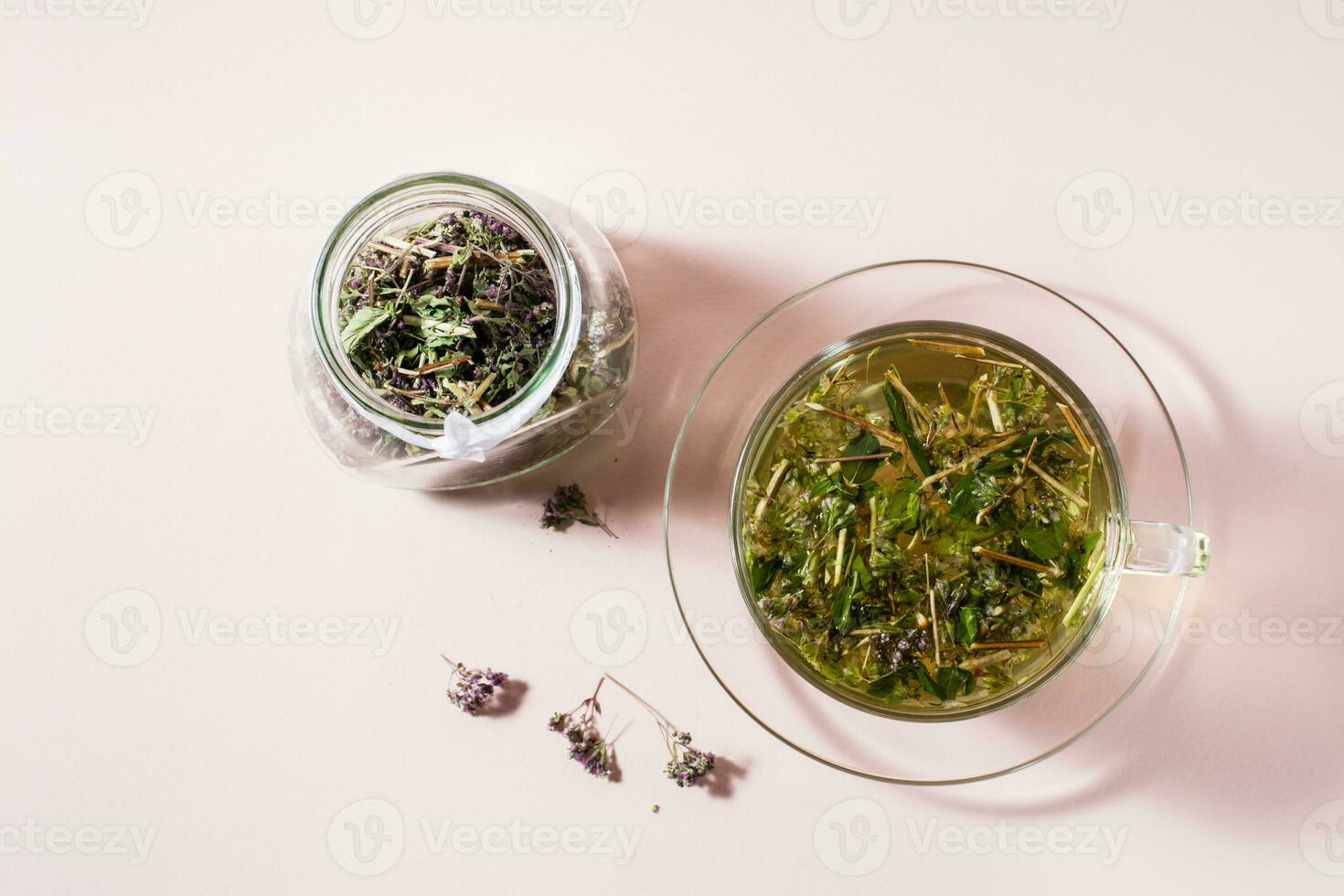 Fresh hot tea with oregano in a cup and dry herb in a jar. Herbal medicine and alternative therapy. Top view photo