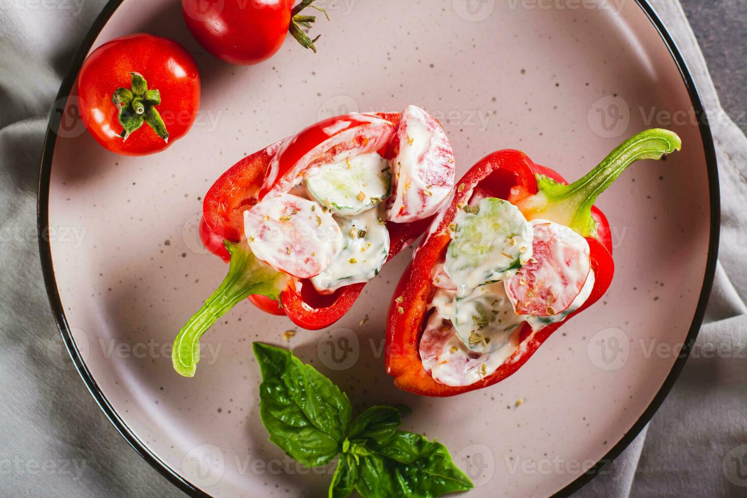 Close up of bell pepper stuffed with cucumber, tomato and greek yogurt on a plate top view photo