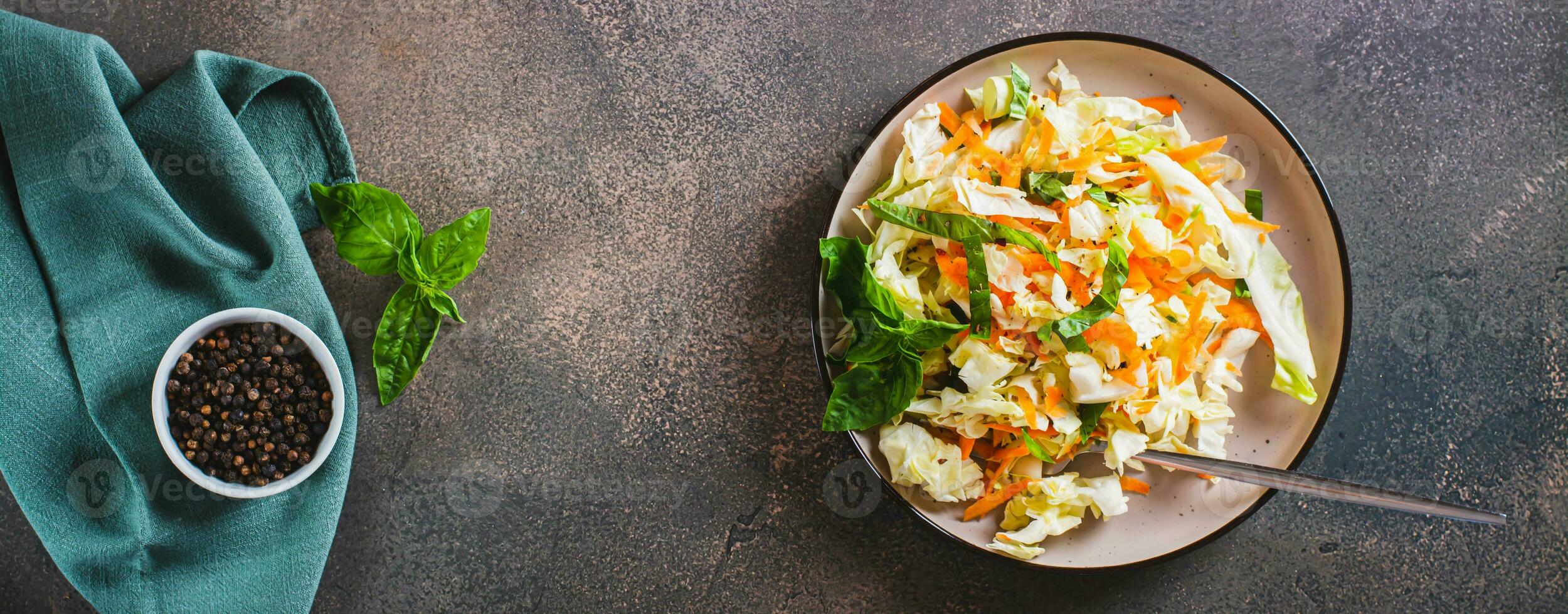 Salad cole slaw with fresh cabbage, carrots and basil on a plate top view web banner photo